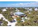 Expansive aerial view of beach home surrounded by lush greenery, steps to the beach and gorgeous water views at 32 Palm Dr, Placida, FL 33946