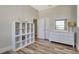 Bedroom with built-in shelving, dresser, and natural light from a window on hardwood floors at 32 Palm Dr, Placida, FL 33946