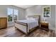 Comfortable bedroom featuring a large window view, side tables, and a queen bed on hardwood floors at 32 Palm Dr, Placida, FL 33946