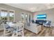 Comfortable living room with hardwood floors, TV, a white sofa, and a dining area with large windows at 32 Palm Dr, Placida, FL 33946