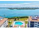 Aerial view of a community pool, surrounded by manicured lawns and overlooking serene waters at 3540 Gulf Of Mexico Drive # 202, Longboat Key, FL 34228