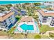 Aerial view of a condo complex with a geometric shaped pool and plenty of patio seating at 3540 Gulf Of Mexico Drive # 202, Longboat Key, FL 34228