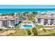 Aerial view of a condo complex with a swimming pool and the ocean in the background at 3540 Gulf Of Mexico Drive # 202, Longboat Key, FL 34228
