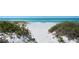 Sandy beach with lush greenery, leading to the ocean at 3540 Gulf Of Mexico Drive # 202, Longboat Key, FL 34228