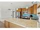 Bright kitchen featuring a granite island, stainless steel appliances, and stylish lighting at 3540 Gulf Of Mexico Drive # 202, Longboat Key, FL 34228
