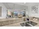 Bright kitchen featuring granite countertops and stainless sink overlooking living room at 3540 Gulf Of Mexico Drive # 202, Longboat Key, FL 34228