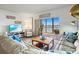 Bright living area with sofas and access to the screened in porch and a view of the water at 3540 Gulf Of Mexico Drive # 202, Longboat Key, FL 34228