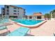 Inviting community pool with ample lounge chairs and a meticulously kept building behind it at 3540 Gulf Of Mexico Drive # 202, Longboat Key, FL 34228