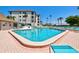 Community pool with lounge chairs and meticulously kept building in the background at 3540 Gulf Of Mexico Drive # 202, Longboat Key, FL 34228