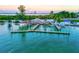 Waterfront restaurant with outdoor seating, a dock, and stunning water views at 3540 Gulf Of Mexico Drive # 202, Longboat Key, FL 34228