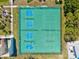 An aerial view shows a green tennis court surrounded by trees and a building with kayaks at 3540 Gulf Of Mexico Drive # 202, Longboat Key, FL 34228