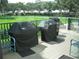Outdoor grilling area on a deck, complete with covered grills, seating, and a view of green space at 3620 Ironwood Cir # 506-O, Bradenton, FL 34209