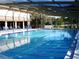 Large community pool surrounded by lounge chairs and a covered recreation area at 3620 Ironwood Cir # 506-O, Bradenton, FL 34209