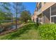 Backyard of a townhome featuring a tranquil pond, lush green grass, and privacy landscaping at 3671 Parkridge Cir # 8-201, Sarasota, FL 34243