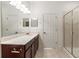 Bright bathroom with walk-in shower, dark cabinets, and large mirror at 3671 Parkridge Cir # 8-201, Sarasota, FL 34243