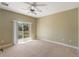 Bright bedroom with ceiling fan, neutral tones, and sliding door leading to balcony at 3671 Parkridge Cir # 8-201, Sarasota, FL 34243