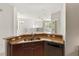 Open kitchen area featuring wood cabinetry and stone countertops overlooking living area at 3671 Parkridge Cir # 8-201, Sarasota, FL 34243