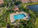 Aerial view of a resort-style pool surrounded by lush landscaping, loungers, and shade structures at 3671 Parkridge Cir # 8-201, Sarasota, FL 34243