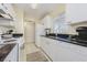 Well-lit kitchen with white appliances, granite countertops, and tiled flooring for easy maintenance at 3690 Pinecrest St # 124, Sarasota, FL 34232