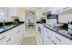 Bright kitchen features white cabinets, black granite countertops, and a view into the dining area at 3690 Pinecrest St # 124, Sarasota, FL 34232