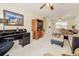 Inviting living room with neutral carpet, ceiling fan, and a workspace near a sliding glass door at 3690 Pinecrest St # 124, Sarasota, FL 34232