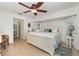 Main bedroom with white furniture, ceiling fan, and ensuite bathroom at 3736 Fontainebleau St, North Port, FL 34287
