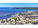 Aerial view of coastal neighborhood featuring waterfront homes, private docks, and canals near a bay under a clear blue sky at 4405 Harbor Blvd, Port Charlotte, FL 33952