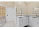 Bright bathroom with granite counters, white cabinetry and tile floors at 4405 Harbor Blvd, Port Charlotte, FL 33952