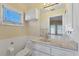 Cozy bathroom features a marble vanity, built-in storage, and window allowing natural light at 4405 Harbor Blvd, Port Charlotte, FL 33952