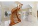 Grand foyer with winding wooden staircase and high ceilings, creating a welcoming and elegant entrance at 4405 Harbor Blvd, Port Charlotte, FL 33952