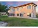 Rear exterior view of a two-story home featuring large windows, a screened lanai, and a well-maintained lawn at 4405 Harbor Blvd, Port Charlotte, FL 33952