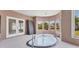 Enclosed hot tub room with surrounding windows that bring in natural light and doors to a screened area at 4405 Harbor Blvd, Port Charlotte, FL 33952