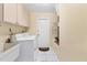Functional laundry room with utility sink, washer, dryer, and ample storage for cleaning supplies at 4405 Harbor Blvd, Port Charlotte, FL 33952