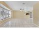 Bright living space with tile flooring, fan, and a large bay window overlooking the front yard at 4405 Harbor Blvd, Port Charlotte, FL 33952