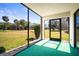 An enclosed lanai with green carpet offers picturesque views of the outdoor landscape at 4580 Longwater # 61, Sarasota, FL 34235