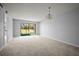 Bright, spacious living area with neutral carpet, and sliding glass doors overlooking golf course at 4580 Longwater # 61, Sarasota, FL 34235