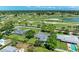 Aerial view of a single-level home near a golf course, ponds, and mature trees under a partly cloudy sky at 4611 17Th W Ave, Bradenton, FL 34209