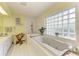 Bright bathroom features a soaking tub with jets, glass block window, and double sink vanity at 4611 17Th W Ave, Bradenton, FL 34209