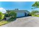 A single-level home with a two-car garage and an asphalt driveway lined with mature bushes and trees at 4611 17Th W Ave, Bradenton, FL 34209