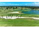 Scenic aerial shot of the golf course featuring lush green fairways, water hazards and mature trees under a blue sky at 4611 17Th W Ave, Bradenton, FL 34209