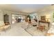 A living room with neutral carpeted floors features a view of the open dining and Gathering room concept at 4611 17Th W Ave, Bradenton, FL 34209