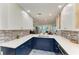 This kitchen features a sink with ocean views, white countertops, blue cabinets, and backsplash at 5055 Gulf Of Mexico Dr # 232, Longboat Key, FL 34228