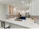 Open concept kitchen features white countertops, blue cabinets, stainless steel appliances, and bright lighting at 5055 Gulf Of Mexico Dr # 232, Longboat Key, FL 34228