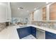 Open concept kitchen features white countertops, blue cabinets, stainless steel appliances, and ocean views at 5055 Gulf Of Mexico Dr # 232, Longboat Key, FL 34228