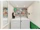 Laundry room with washer, dryer, shelving, and a mirror at 5055 Gulf Of Mexico Dr # 232, Longboat Key, FL 34228