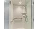 Tiled shower with glass door, handheld shower head, and safety bar at 5055 Gulf Of Mexico Dr # 232, Longboat Key, FL 34228