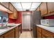 Open kitchen with wood cabinets, stainless steel appliances, and neutral flooring at 519 Albee Farm Rd # 201, Venice, FL 34285