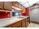 Open kitchen view with wood cabinets, stainless steel sink, and pass-through window at 519 Albee Farm Rd # 201, Venice, FL 34285