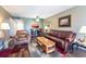 Comfortable living room featuring updated laminate floors, leather furniture and a kitchen breakfast bar at 519 Albee Farm Rd # 201, Venice, FL 34285