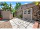 Garage exterior with stone details, concrete tiles, wood accents and lush green trees at 528 45Th St, Sarasota, FL 34234